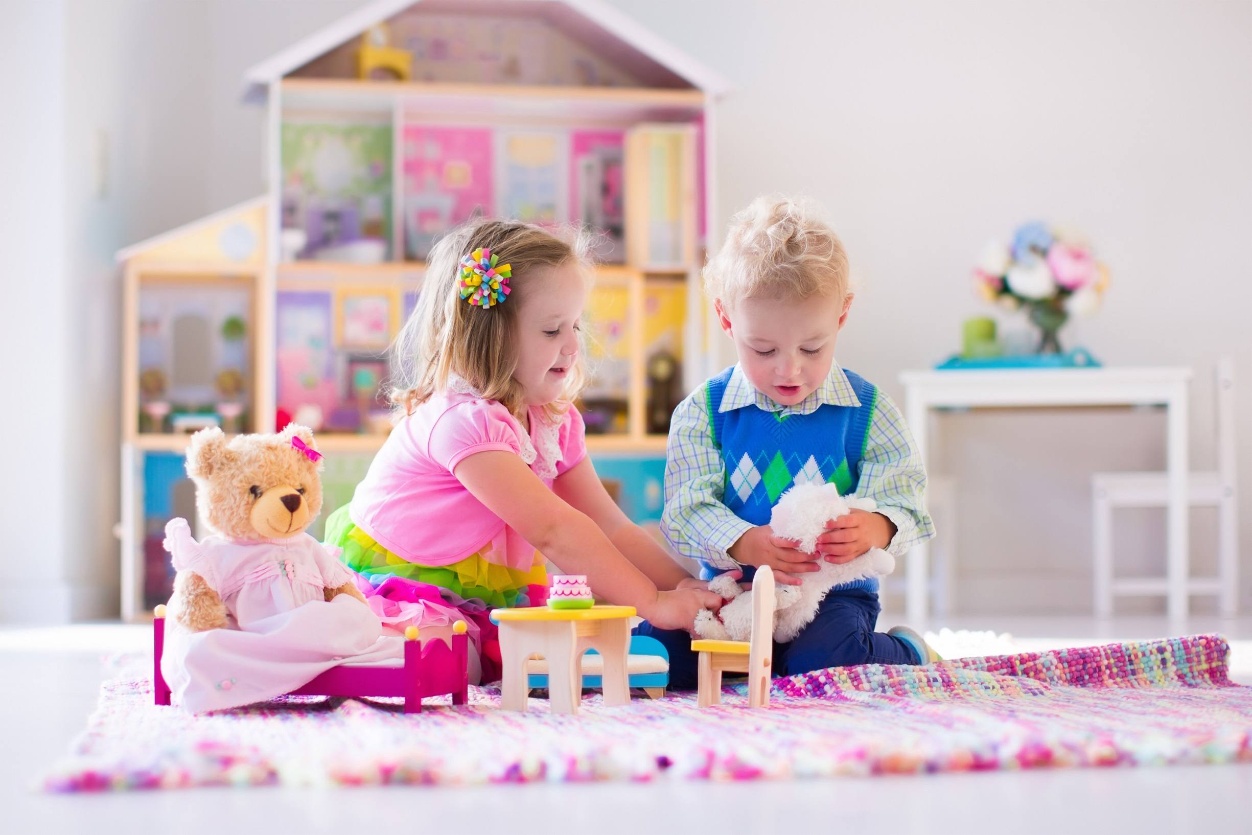 Adorable kids playing with stuffed animals and doll house