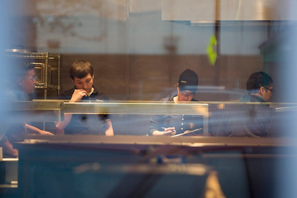 Employees work inside of Chipotle Mexican Grill Employees work inside of Chipotle Mexican Grill