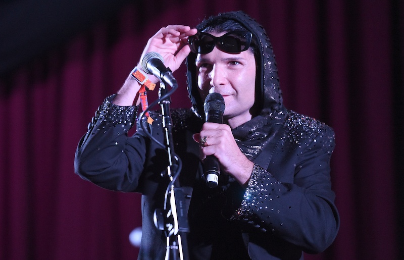 Corey Feldman adjusting his sunglasses on stage. Corey Feldman adjusting his sunglasses on stage.