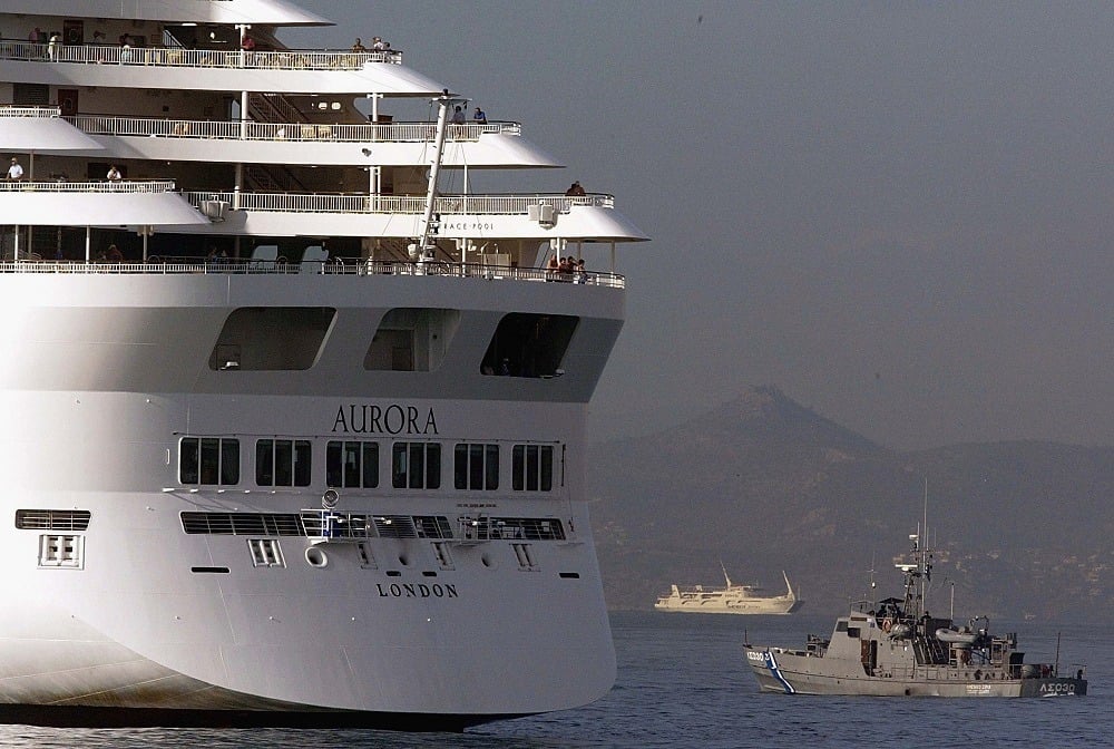 A Greek coast guard boat patrols around a cruise
