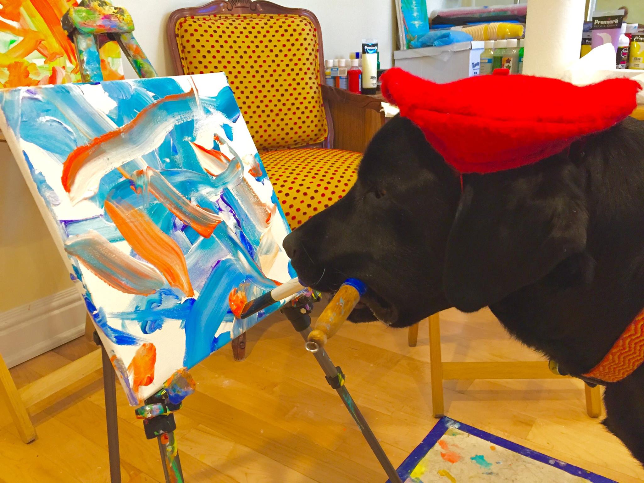 Dog wearing a red beret and painting