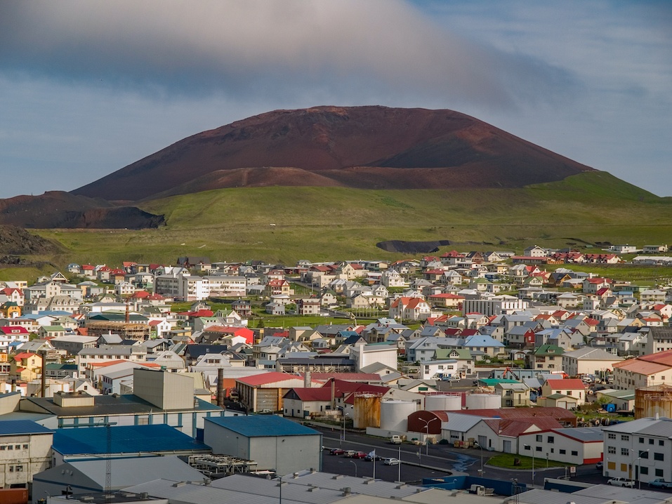 Eldfell volcano in front of cityscape in Heimaey