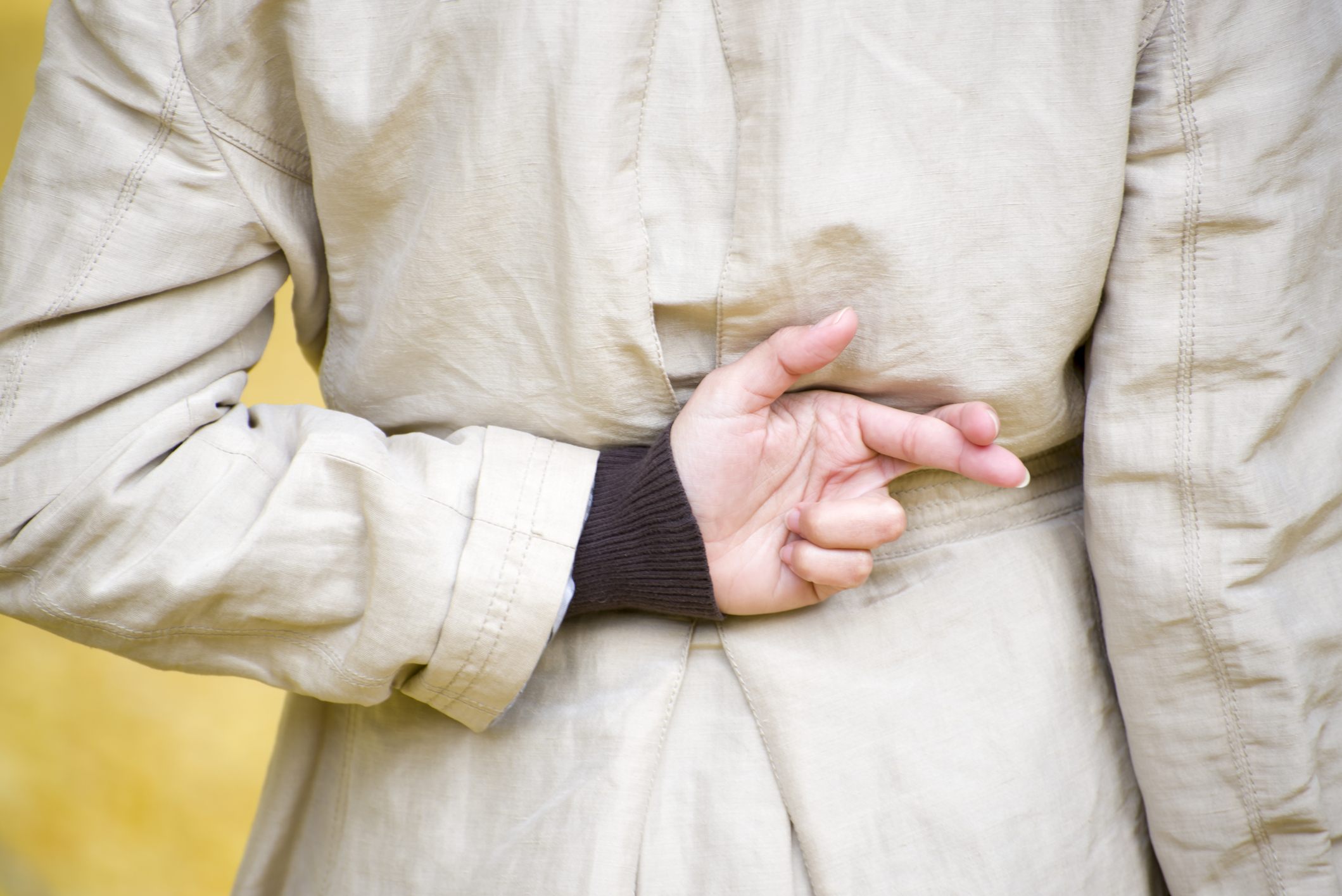Woman crossing fingers behind her back Woman crossing fingers behind her back
