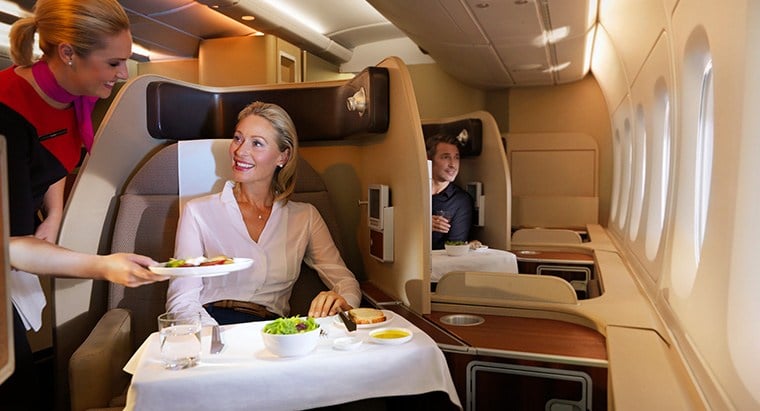 Woman being served food in Qantas airlines first class.