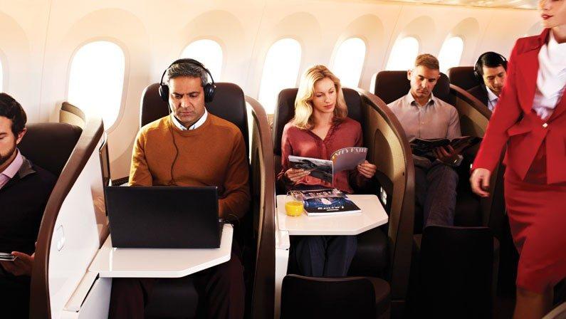 Passengers sitting and working in the first class section of Virgin Atlantic plane.