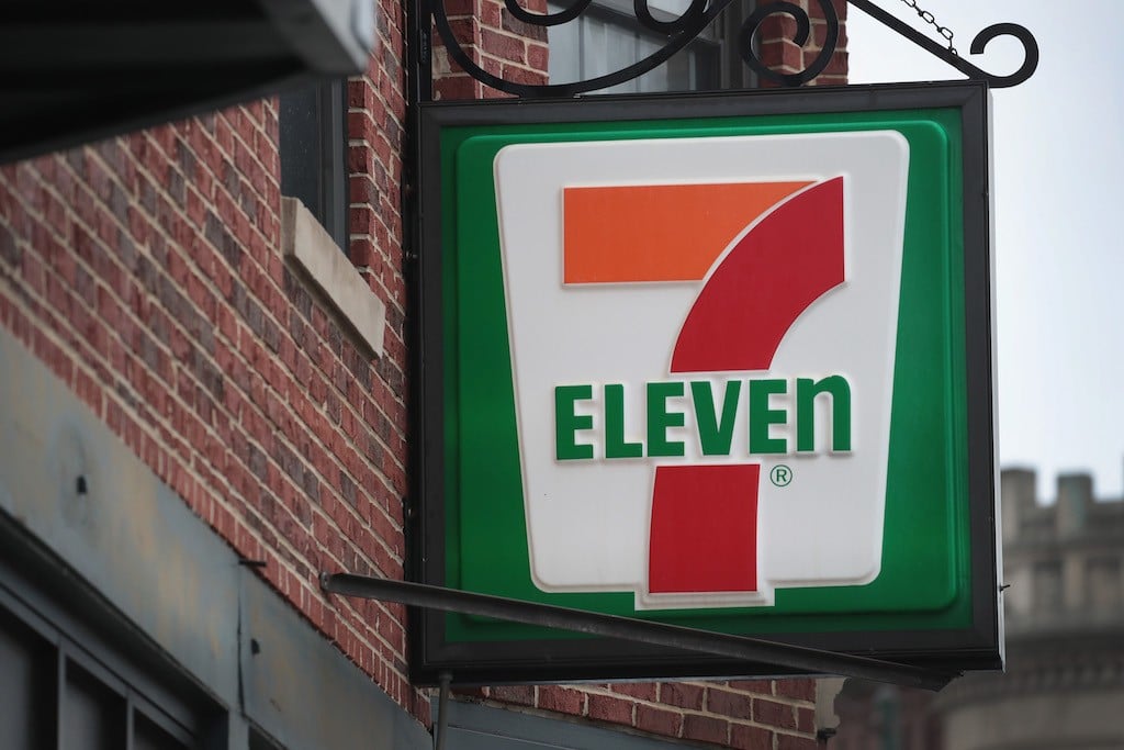A sign hangs outside of a 7-Eleven store