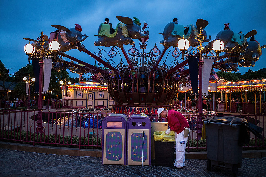 A staff member cleans the garbage bin inside Disneyland