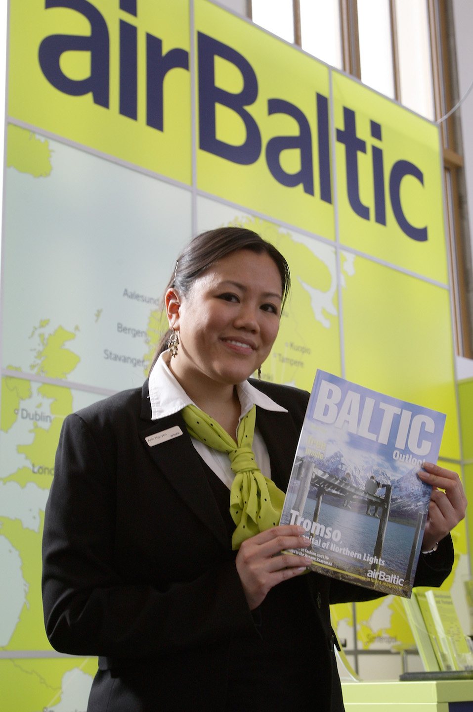 An employee of airliner Air Baltic holds a board magazin at the ITB
