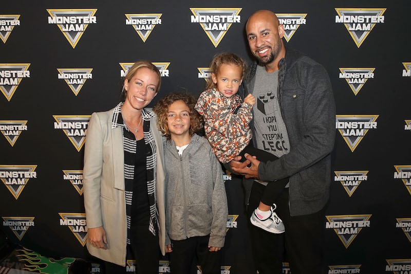 Kendra smiles on a red carpet with her family. 