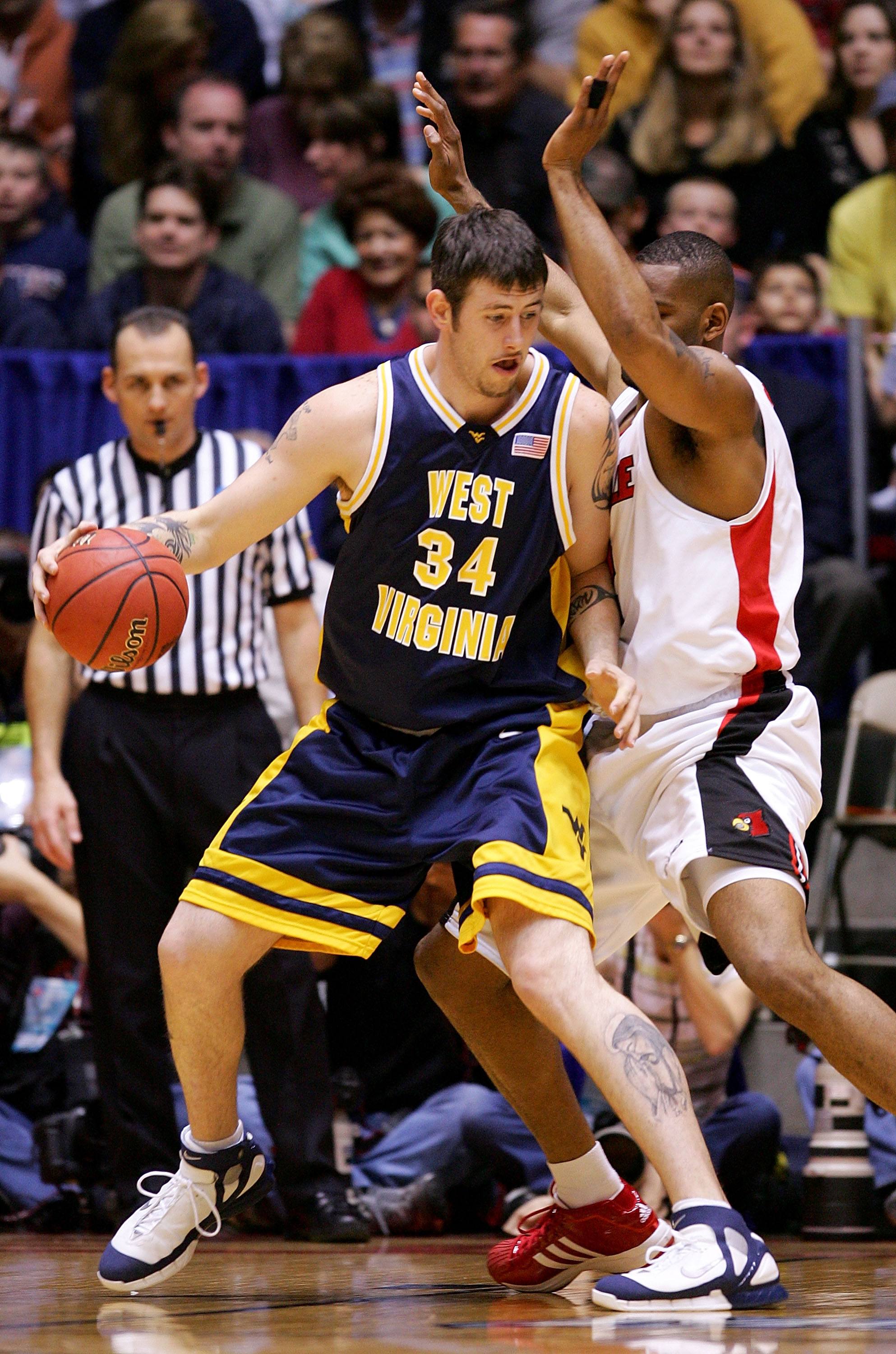 Kevin Pittsnogle #34 of the West Virginia Mountaineers goes up against Ellis Myles #2 of the Louisville Cardinals