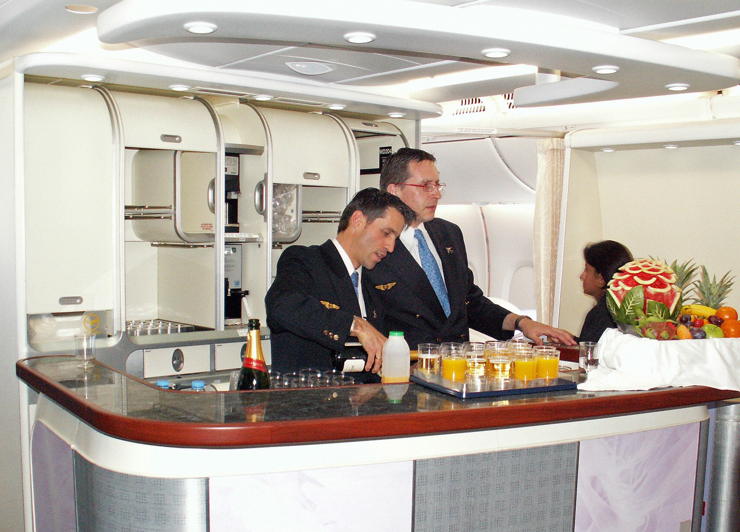 Stewards prepare drinks in the first class bar of Lufthansa aircraft.