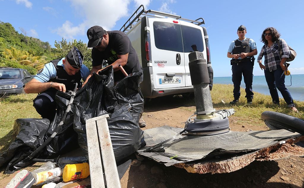A French Gendarme (L) inspects debris