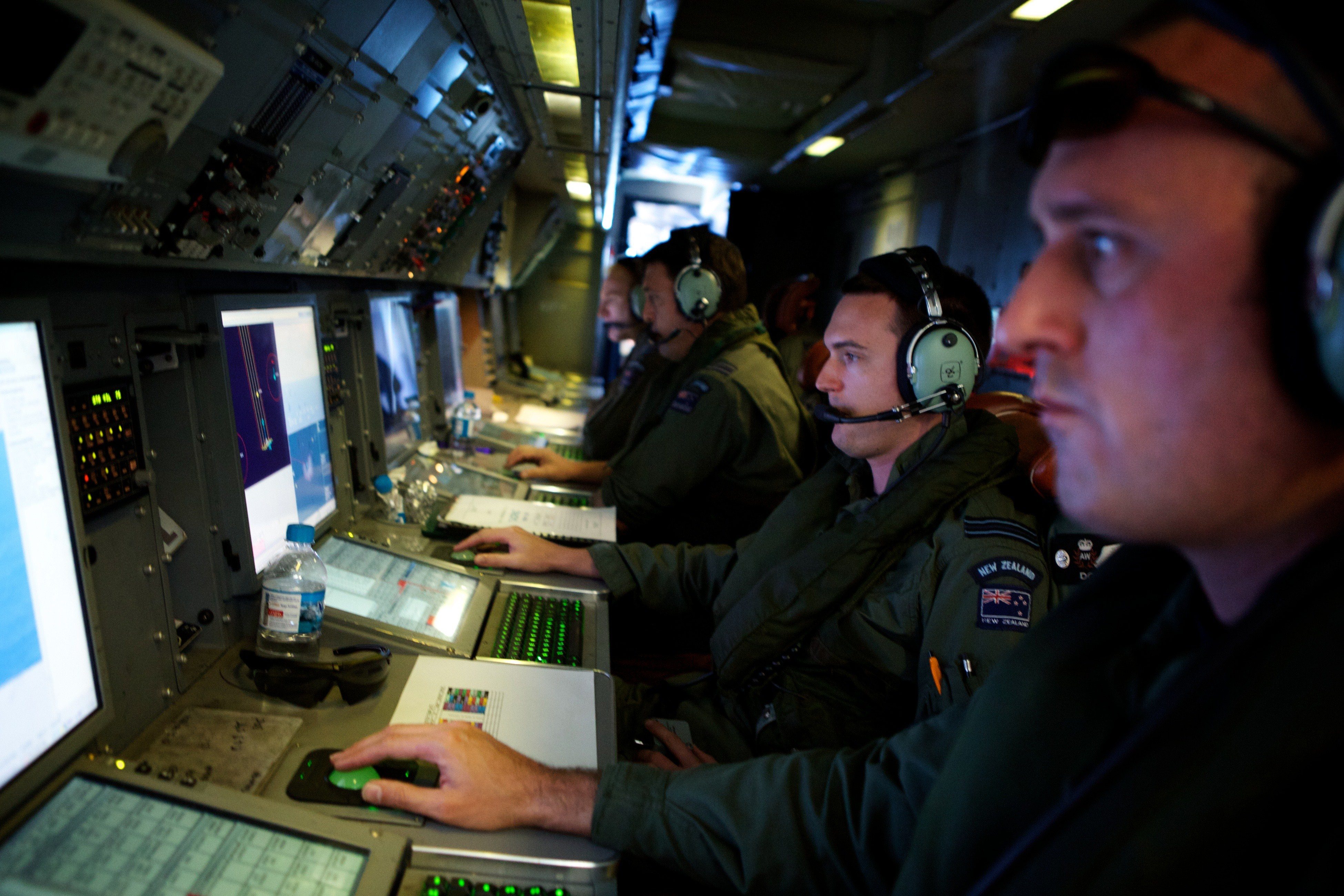 Crew members of a Royal New Zealand Air Force P-3 Orion operate radar