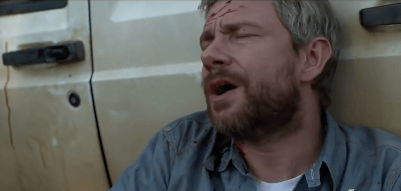Martin Freeman is wounded and laying against a car in 'Cargo'.