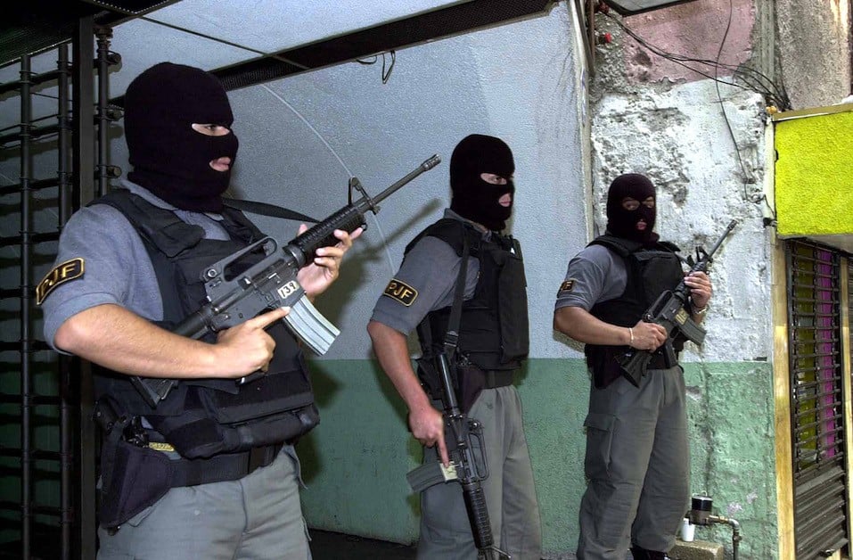 Masked Mexican police stand guard during a raid of a currency exchange store