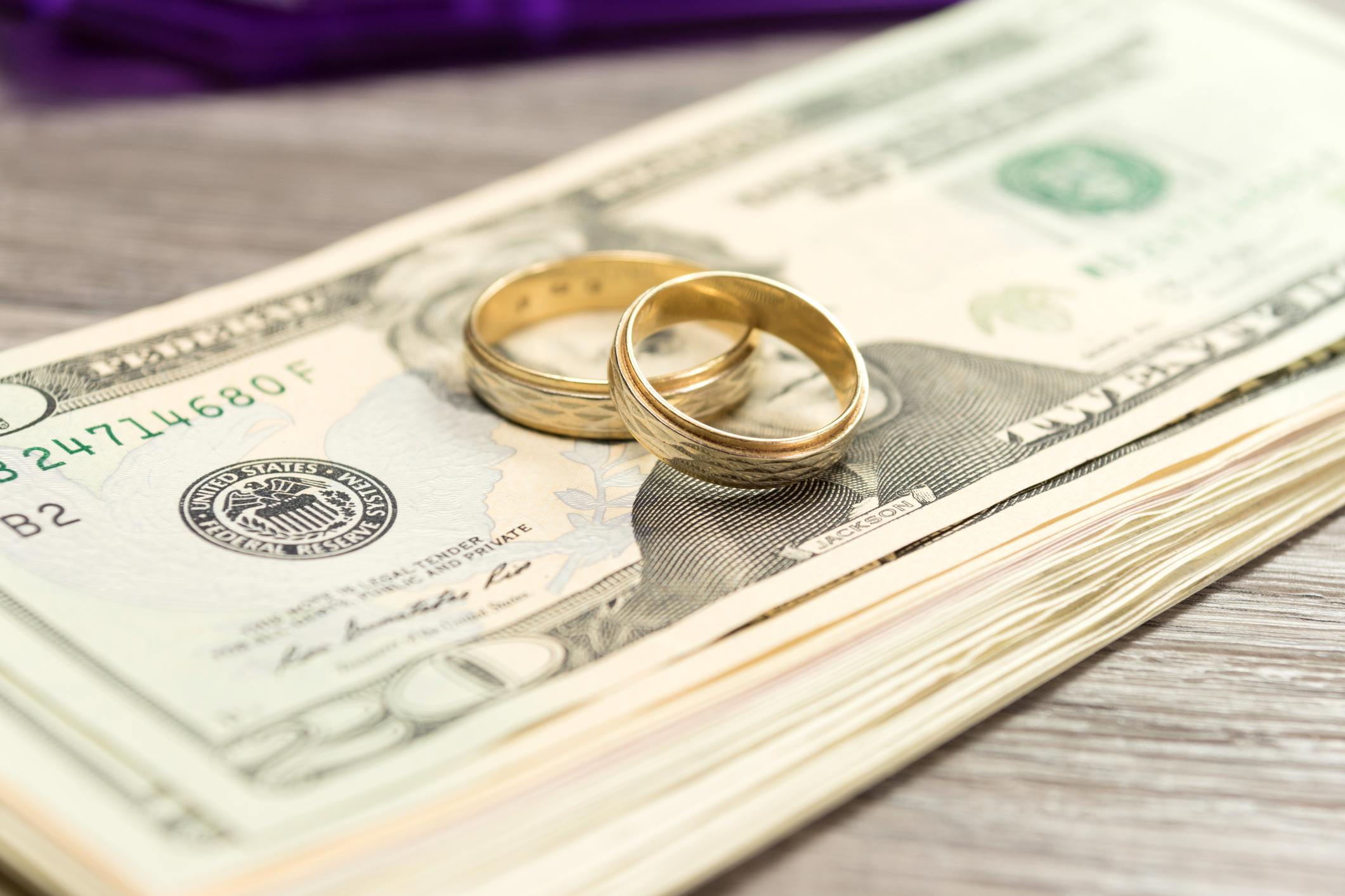 Wedding rings on top of stack of money.