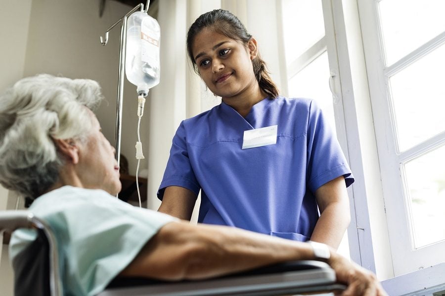 Nurse standing with old patient