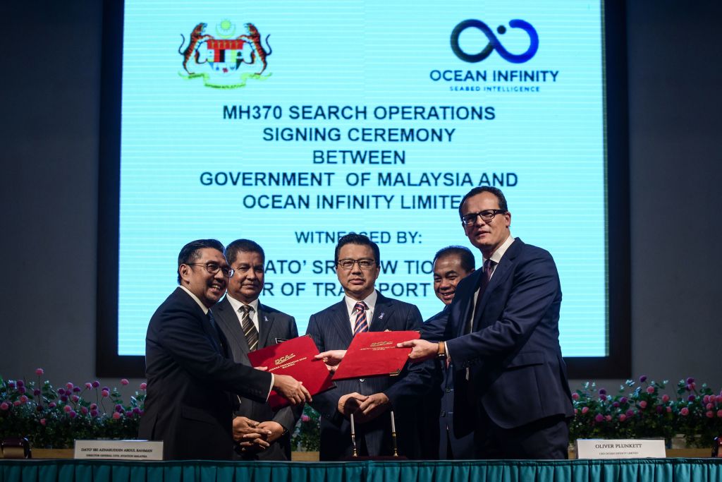 Director general of Malaysia's Civil Aviation Department (DCA) Azharuddin Abdul Rahman (L) exchanges documents with CEO of Ocean Infinity Limited Oliver Plunkett