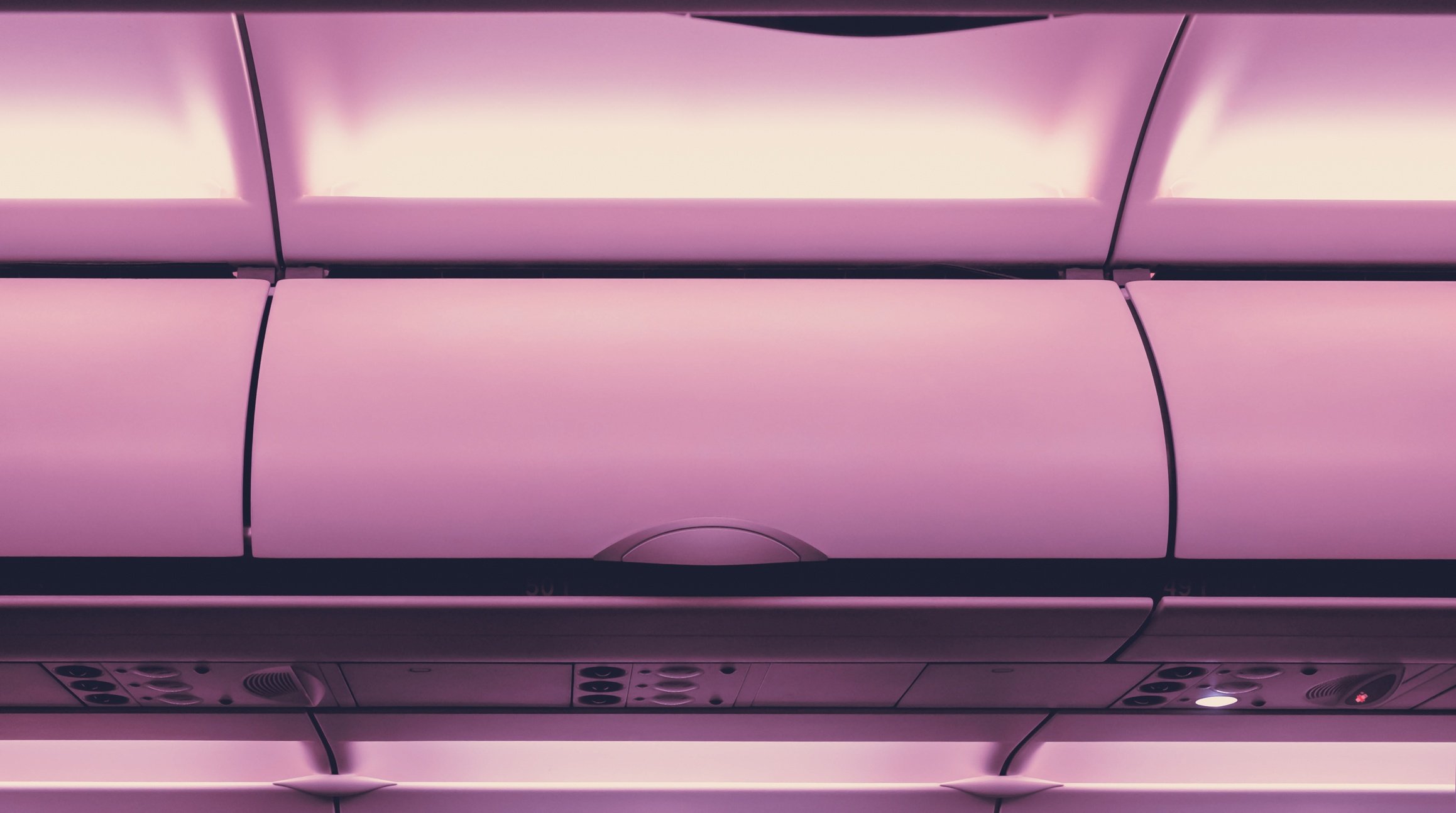 Close overhead bin of airplane with purple cast
