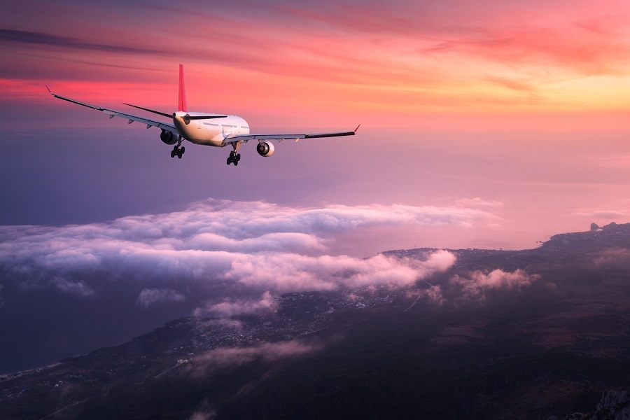 airplane is flying in the red sky