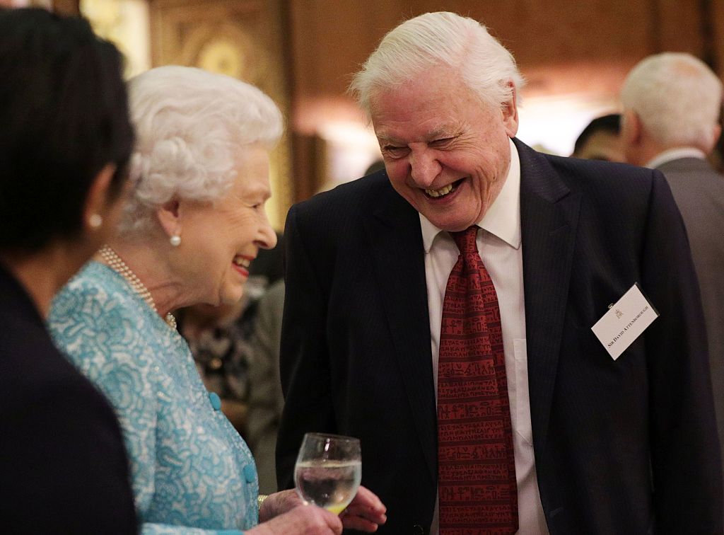 Britain's Queen Elizabeth II (L) reacts as she talks with television presenter David Attenborough