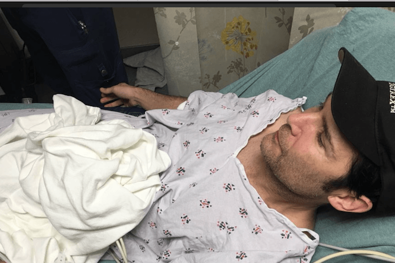 Corey Feldman in a hospital bed