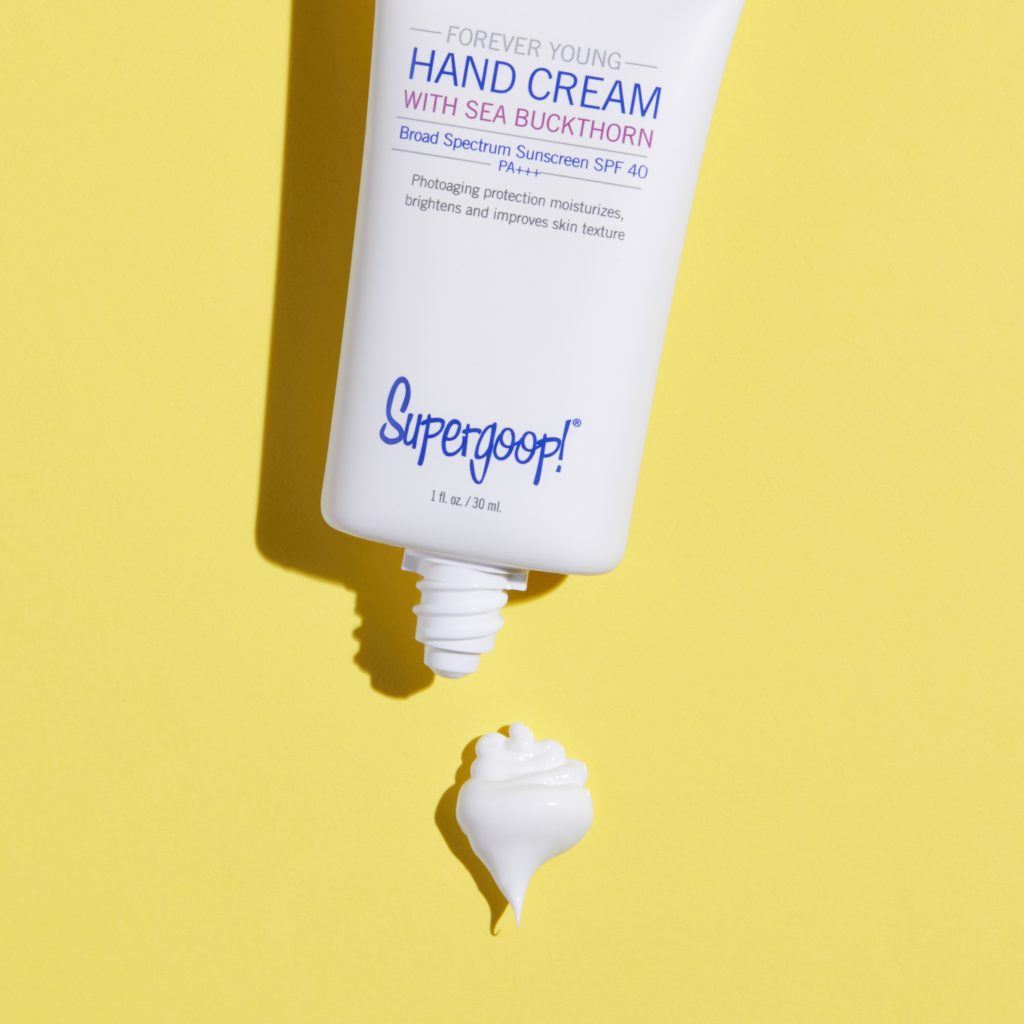 Supergoop hand cream on yellow backgrounda