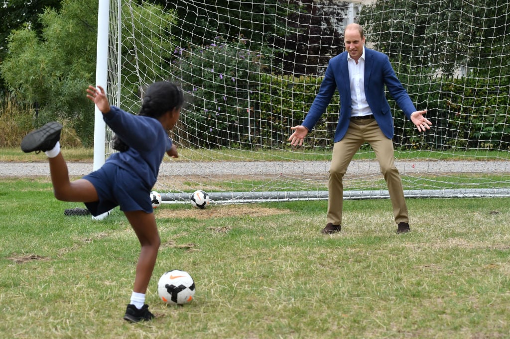 Prince William, Duke of Cambridge takes his turn in goal up against a member of the Wildcats Girl' Football programme