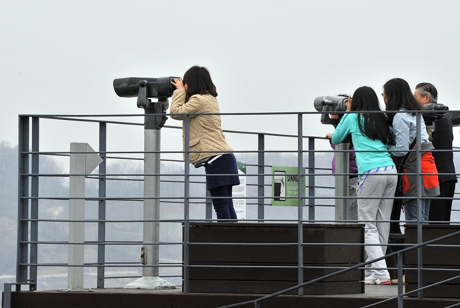 Tourists watching with binoculars at Korean Tourists watching with binoculars at Korean