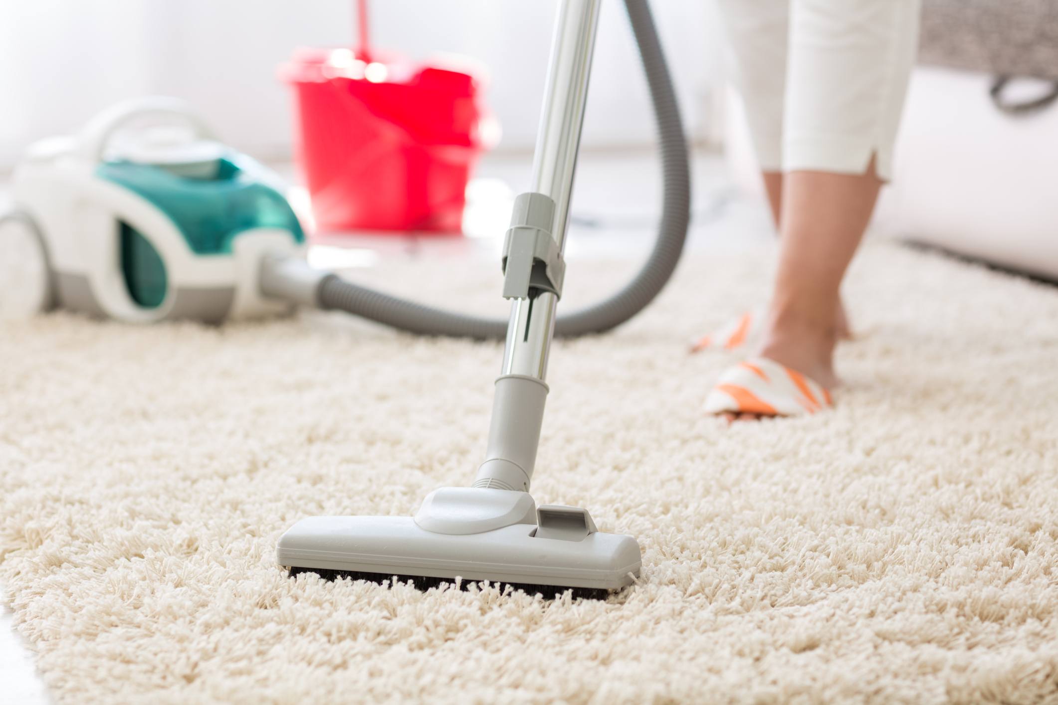 Woman Vacuuming a beige carpet