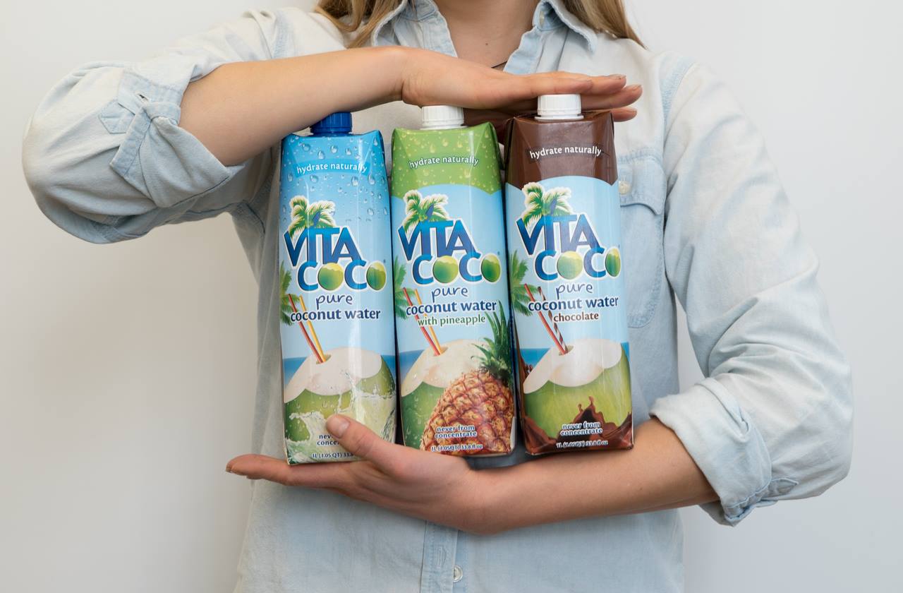 Woman holding three Vita coco coconut water