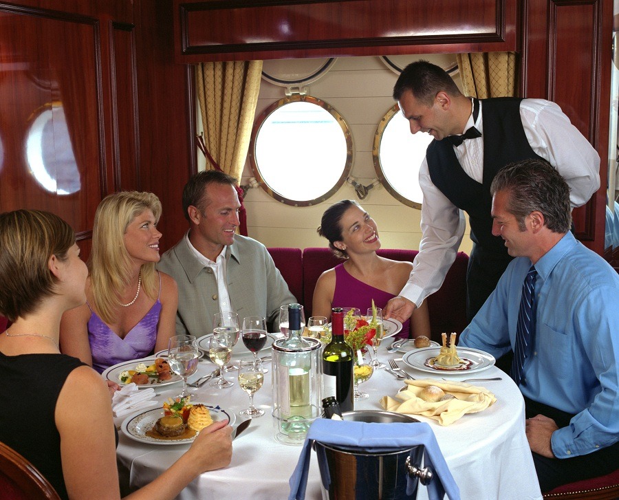 Waiter serving table of five in a cruise ship