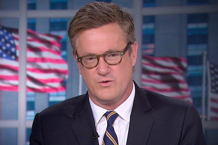 Joe Scarborough sits at a desk Joe Scarborough sits at a desk