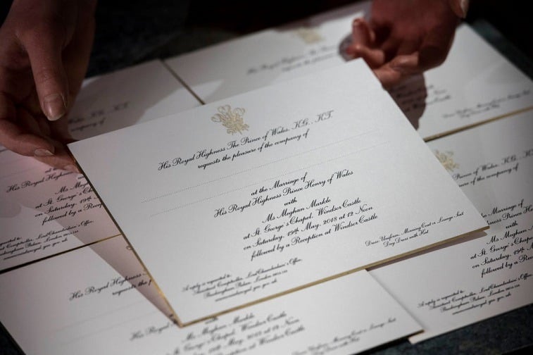 Hands hold invitations just printed at the workshop of Barnard and Westwood for Prince Harry and Meghan Markle's wedding on March 22, 2018 in London, England. The couple will marry in St. George's Chapel at Windsor Castle on May 19.