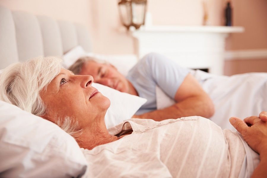 Worried Senior Woman Lying Awake In Bed Worried Senior Woman Lying Awake In Bed