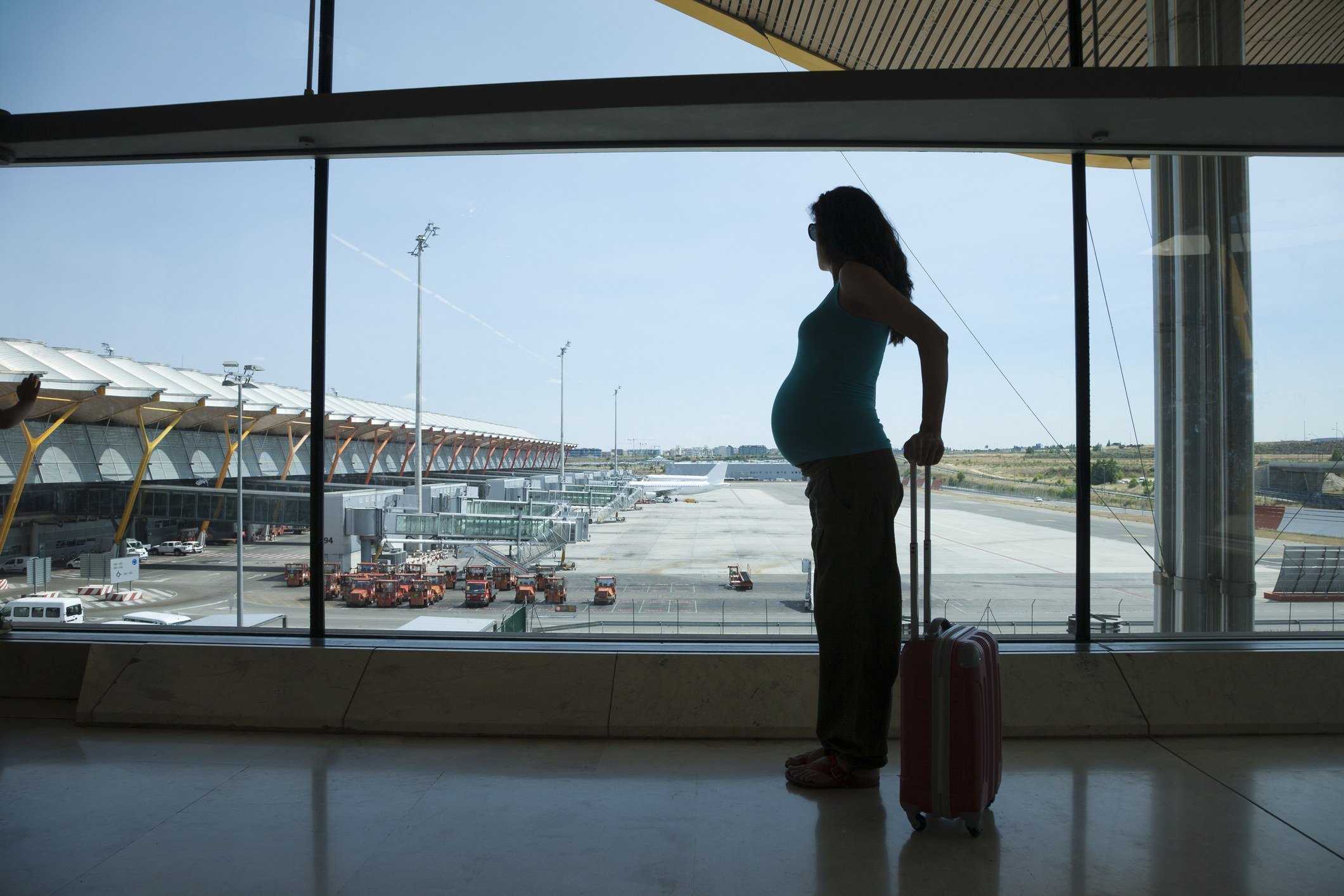 Silhouette of a pregnant woman waiting to fly in airport hall