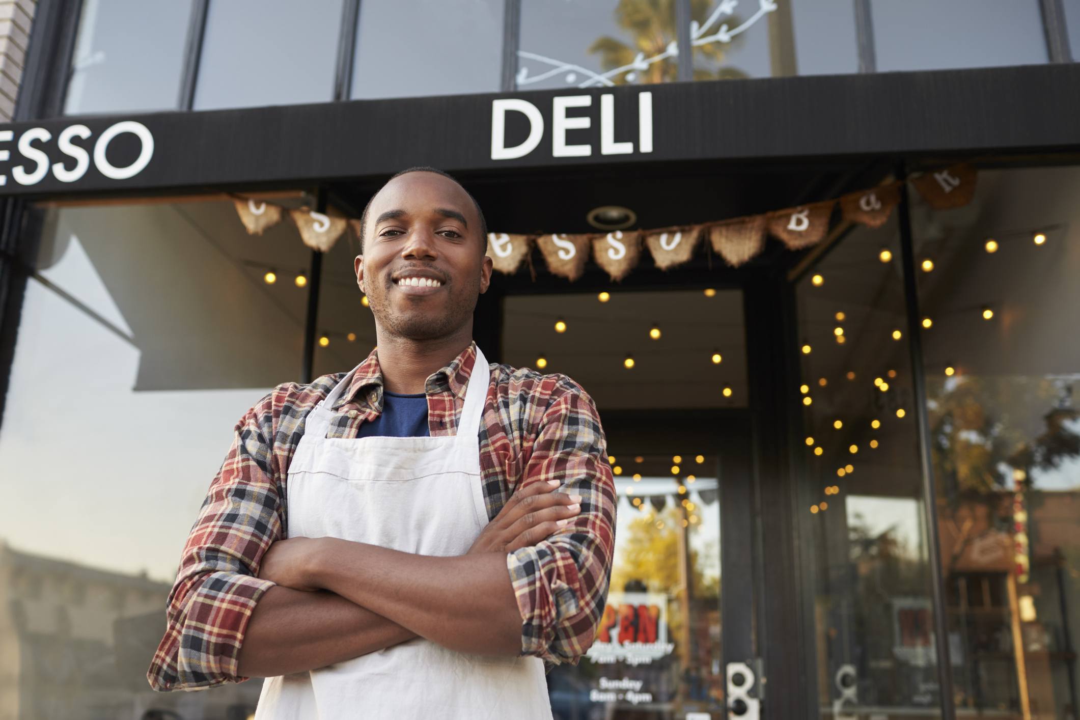 Black male small business owner standing outside coffee shop