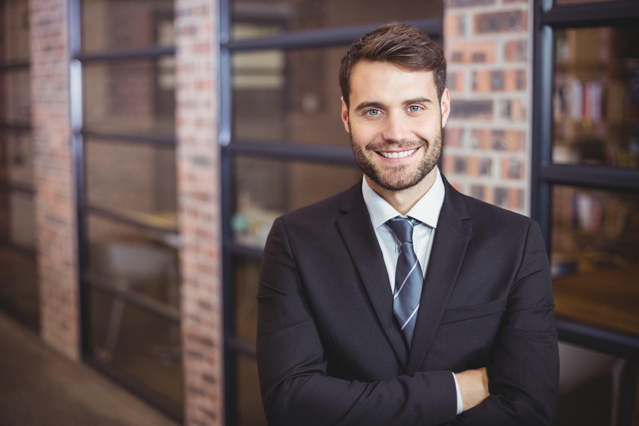 Happy handsome businessman with arms crossed