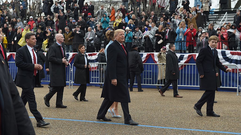 US President Donald Trump walks his wife Melania and son Barron surrounded by Secret Service officers