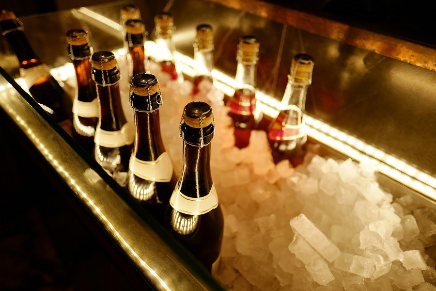 Bottle of champagne in bucket of ice.