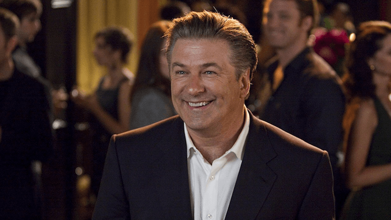 Alec Baldwin smiling while in a suit in 'It's Complicated'. 