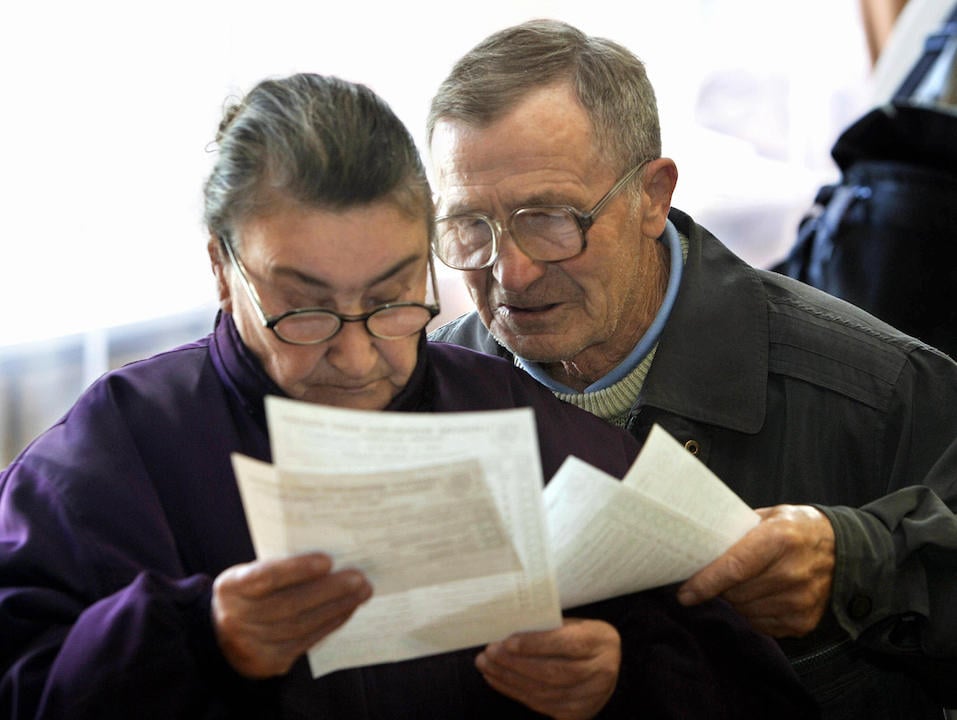 An elderly couple looking at paper work