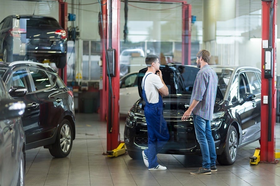 Man having problems with car visiting repair shop Man having problems with car visiting repair shop