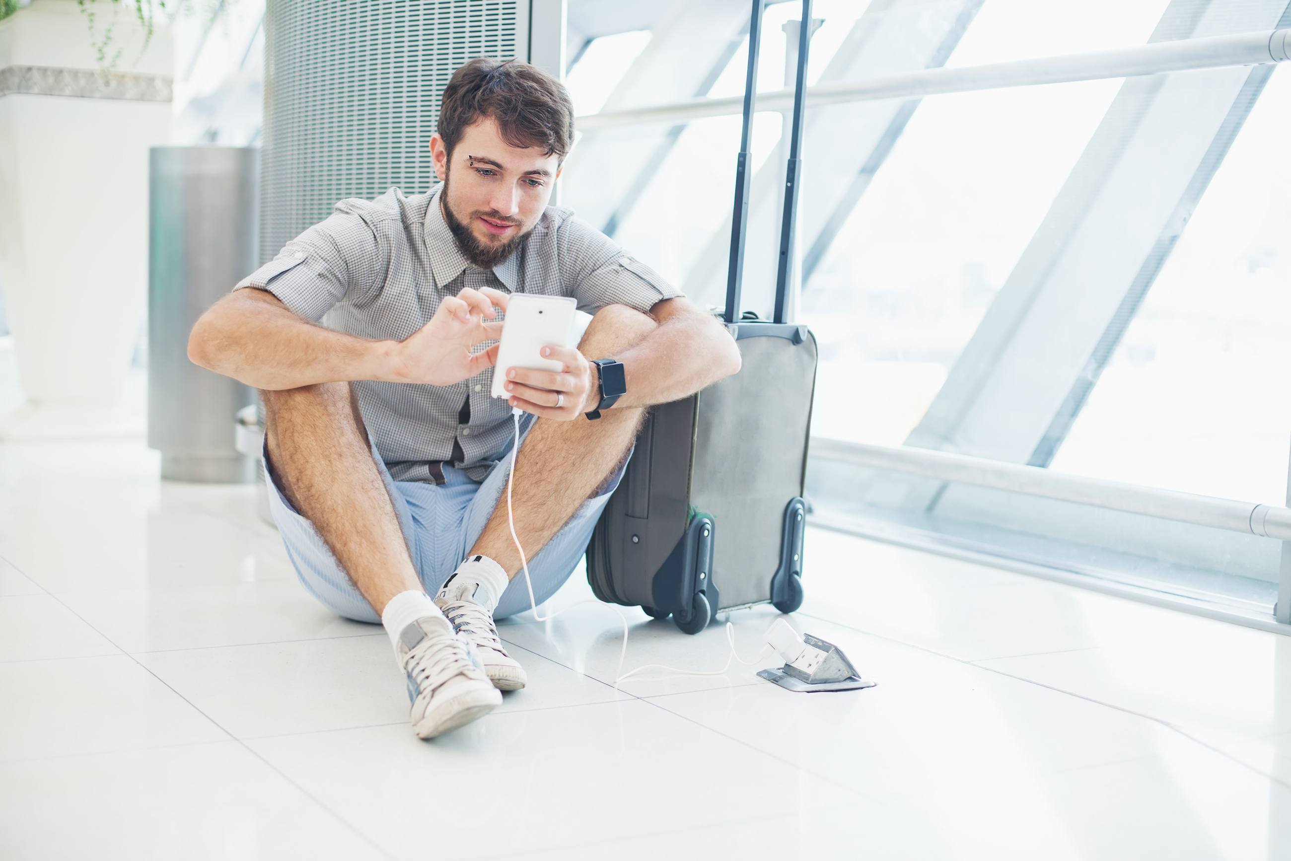 man waiting for his flight at the airport and speaking on his phone