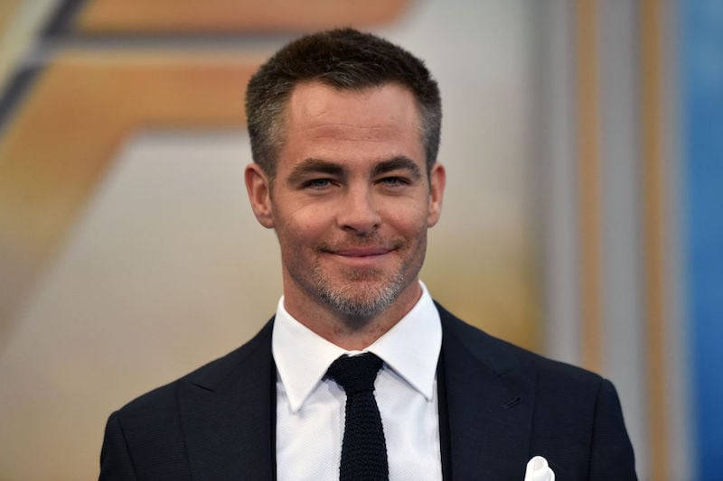 Chris Pine smiling while on a red carpet. 