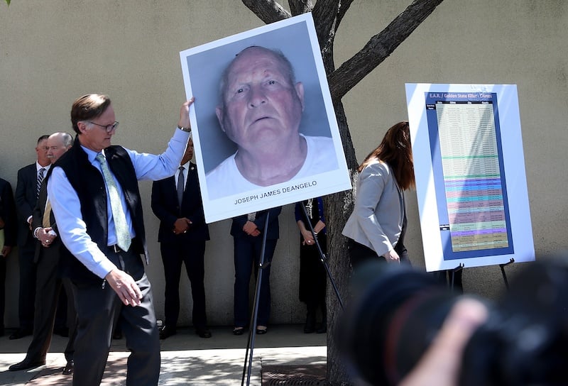 Officials holding DeAngelo's photo during a press conference. 