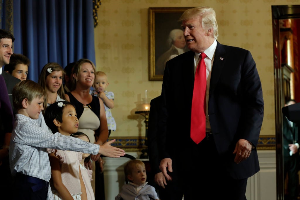 Donald Trump walking past children