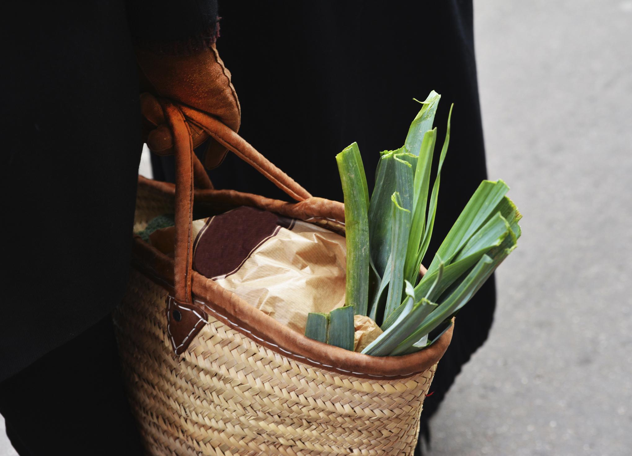 leek in a straw reusable grocery bag farmers market