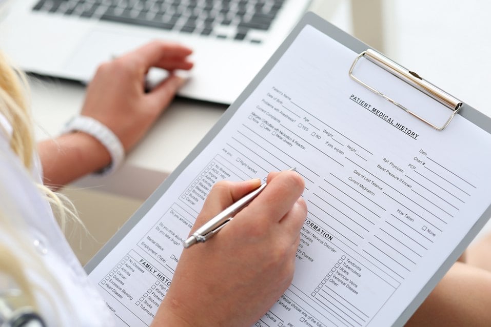 Female doctor hold clipboard pad and fill medical history