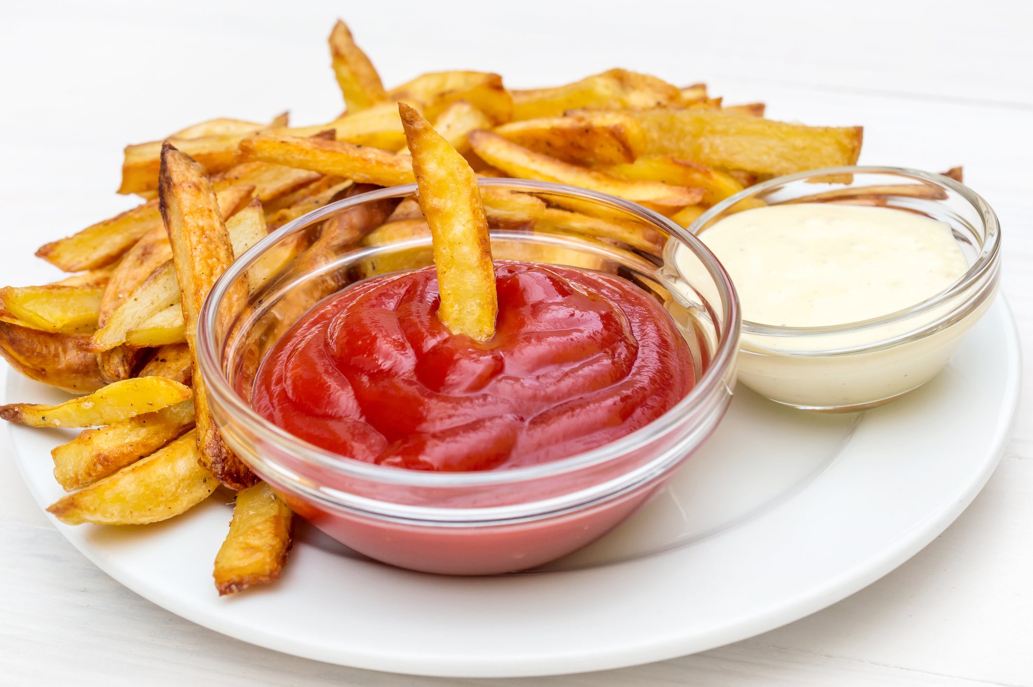 Plate with fries potato, ketchup and mayonnaise on the table.